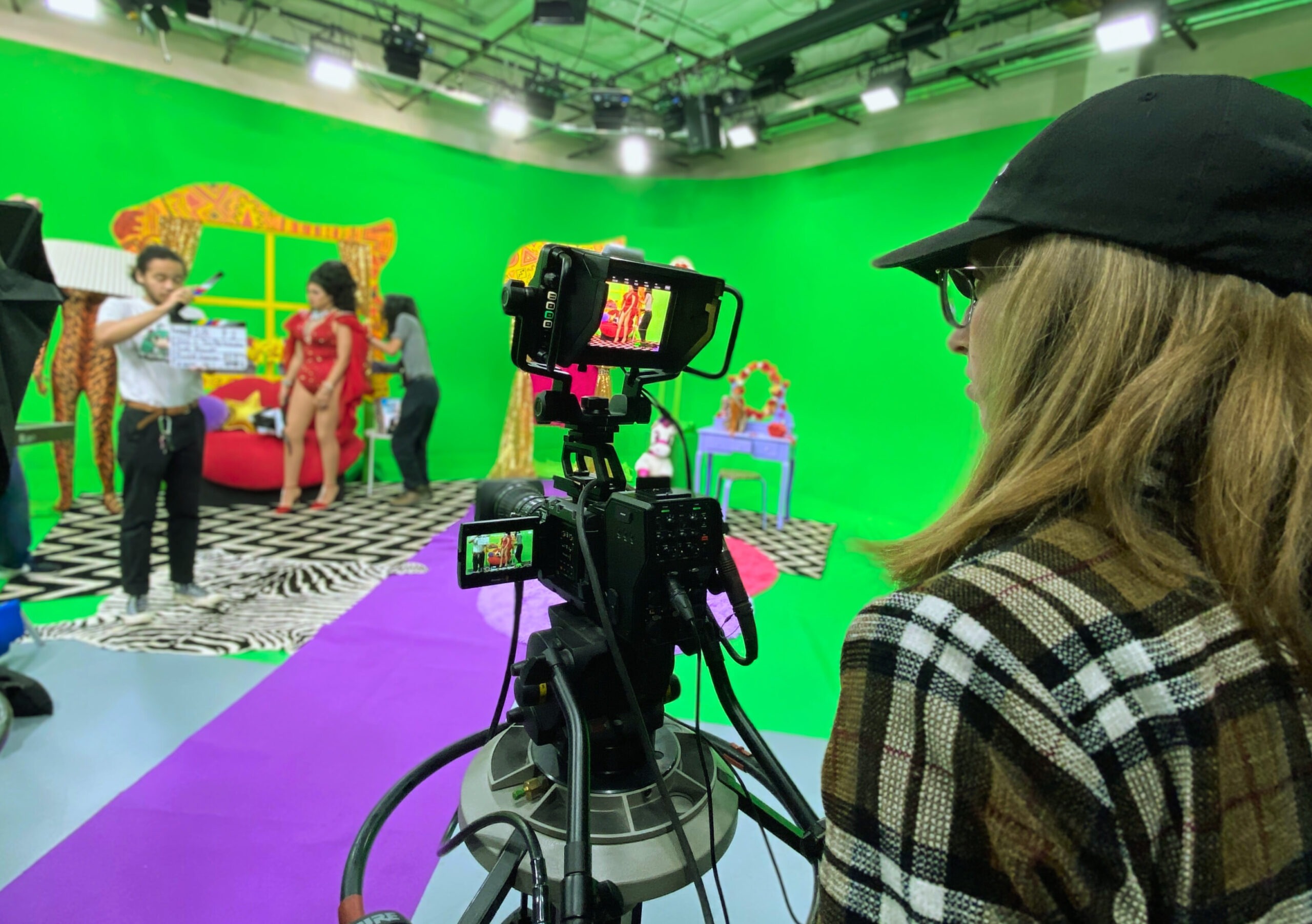 Camera operator and production team on a green-screen studio set at Open Signal